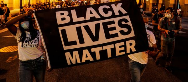People hold up a Black Lives Matter banner as they march during a demonstration against racial inequality in the aftermath of the death in Minneapolis police custody of George Floyd, in Washington, U.S., June 14, 2020 - Sputnik International