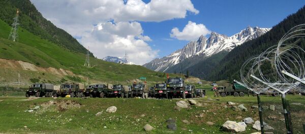 Indian army soldiers walk past their parked trucks at a makeshift transit camp before heading to Ladakh, near Baltal, southeast of Srinagar, June 16, 2020 - Sputnik International