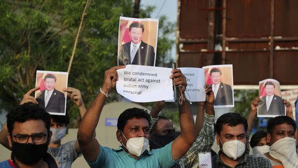 Indians holds photographs of Chinese president Xi Jinping during a protest against China in Ahmedabad, India, Tuesday, June 16, 2020. - Sputnik International