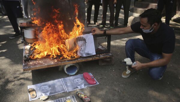 A man burns photographs of Chinese President Xi Jinping during a protest against the Chinese government in Jammu, India, Wednesday, June 17, 2020 - Sputnik International