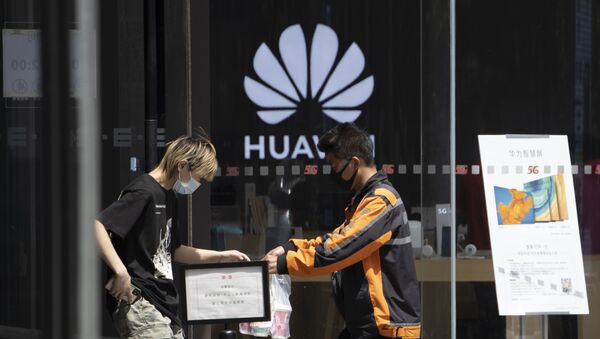 A delivery man hands over drinks near a Huawei retail store in Beijing on Monday, May 18, 2020 - Sputnik International