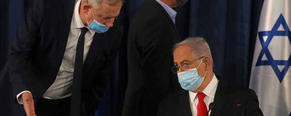 Israeli Prime Minister Benjamin Netanyahu speaks with Alternate Prime Minister and Defence Minister Benny Gantz, as they both wear a protective mask due to the ongoing coronavirus disease (COVID-19) pandemic, during the weekly cabinet meeting in Jerusalem June 7, 2020. - Sputnik International