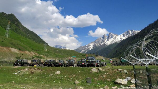 Indian army soldiers walk past their parked trucks at a makeshift transit camp before heading to Ladakh, near Baltal, southeast of Srinagar, June 16, 2020. - Sputnik International