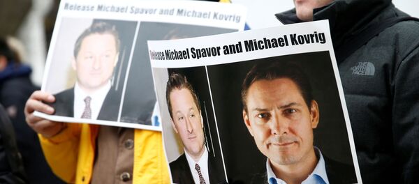 People hold signs calling for China to release Canadian detainees Michael Spavor and Michael Kovrig during an extradition hearing for Huawei Technologies Chief Financial Officer Meng Wanzhou at the B.C. Supreme Court in Vancouver, British Columbia, Canada - Sputnik International