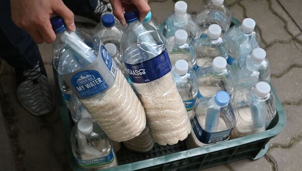 North Korean defector Park Jung-oh checks plastic bottles filled with rice and face masks as he prepares a plan to send the bottles towards North Korea through a border river, in Seoul on June 18, 2020. - North Korea's destruction of its liaison office with the South came after Pyongyang vehemently condemned Seoul for anti-Pyongyang leaflets sent by defectors into the North. - Sputnik International