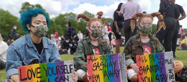Three young people silently hold signs at the London protest Three young people silently hold signs at the London protest - Sputnik International