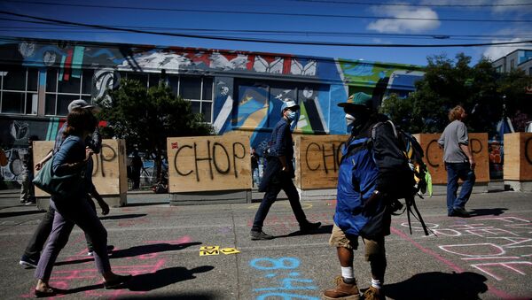 People walk by concrete barriers newly installed by the city as protesters demonstrate against racial inequality and occupy space at the CHOP area near the Seattle Police Department's East Precinct in Seattle, Washington, U.S. June 16, 2020.  - Sputnik International