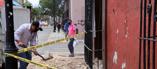 A man removes debris from a building damaged during a quake, in Oaxaca, Mexico - Sputnik International