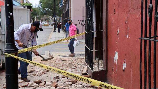 A man removes debris from a building damaged during a quake, in Oaxaca, Mexico - Sputnik International