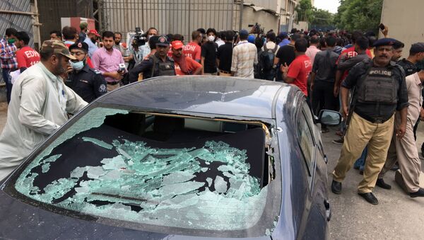 A plainclothes police officer (L) surveys the site of an attack at the Pakistan Stocks Exchange entrance in Karachi June 29, 2020 - Sputnik International