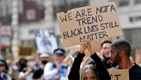A protestors holds up a sign during a Black Lives Matter march in London, Britain, June 28, 2020 - Sputnik International