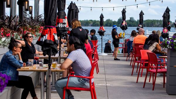 People enjoy drinks and food at Amsterdam Brewhouse's patio, as the provincial phase 2 of reopening from the coronavirus disease (COVID-19) restrictions begins in Toronto, Ontario, Canada June 24, 2020. - Sputnik International