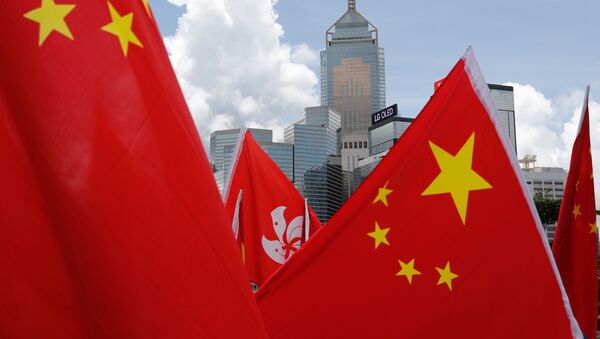 Buildings are seen above the Hong Kong and Chinese flags, as pro-China supporters in Hong Kong celebrated after China's parliament passed national security law for Hong Kong, 30 June 2020 - Sputnik International