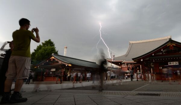 Bolts of lightning strike as people visit Tokyo's Sensoji temple during the preview of the annual two-day Chinese lantern plant fair in Tokyo on 8 July 2013 - Sputnik International