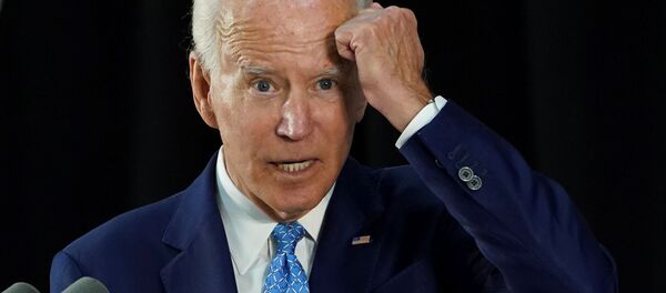 Democratic U.S. presidential candidate and former Vice President Joe Biden gestures with his fist towards his head as he says he has not been tested for coronavirus because he has had no symptoms as my mother would say, knock on wood while answering questions from reporters during a campaign event in Wilmington, Delaware, U.S., June 30, 2020. - Sputnik International