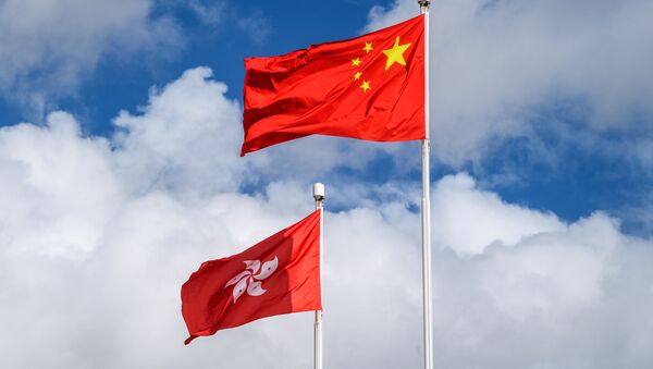 The Chinese (R) and Hong Kong (L) flags are seen hoisted at the end of a flag-raising ceremony to mark the 23rd anniversary of Hong Kong's handover from Britain in Hong Kong on July 1, 2020 - Sputnik International
