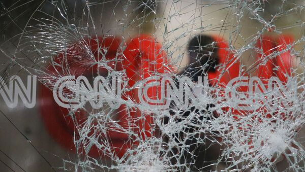 A security guard walks behind shattered glass at the CNN building at the CNN Center in the aftermath of a demonstration against police violence on Saturday, May 30, 2020, in Atlanta. - Sputnik International