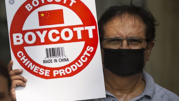 An Indian journalist holds a placard calling for a boycott of Chinese products - Sputnik International