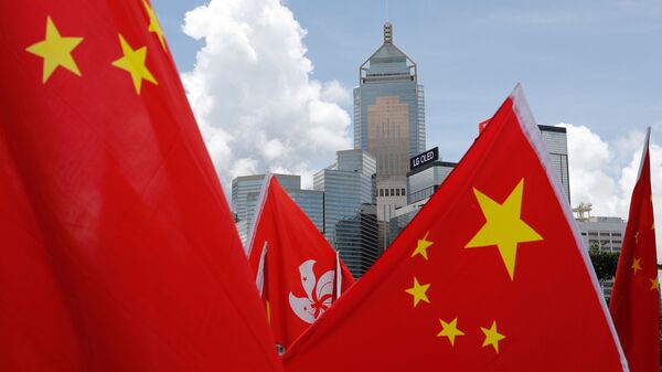 Buildings are seen above Hong Kong and Chinese flags, as pro-China supporters celebration after China's parliament passes national security law for Hong Kong, in Hong Kong, China June 30, 2020.  - Sputnik International
