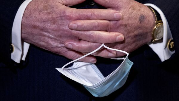 In this June 16, 2020, file photo Senate Majority Leader Mitch McConnell, R-Ky., holds a face mask in his hands during a news conference following a Senate policy luncheon on Capitol Hill in Washington. - Sputnik International