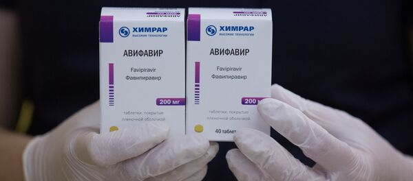 An employee demonstrates packages with new antiviral drug Avifavir, produced by manufacturer ChemRar and approved by Russian authorities to treat patients suffering from the coronavirus disease (COVID-19), at a storage in Moscow, Russia, in this handout photo released June 10, 2020 - Sputnik International