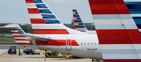 A member of a ground crew walks past American Airlines planes parked at the gate during the coronavirus disease (COVID-19) outbreak at Ronald Reagan National Airport in Washington, U.S., April 5, 2020. A member of a ground crew walks past American Airlines planes parked at the gate during the coronavirus disease (COVID-19) outbreak at Ronald Reagan National Airport in Washington, U.S., April 5, 2020. - Sputnik International
