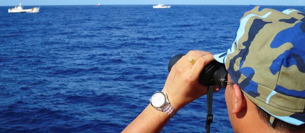 A crewman from the Vietnamese coastguard ship 8003 looks out at sea as Chinese coastguard vessels give chase to Vietnamese ships that came close to the Haiyang Shiyou 981, known in Vietnam as HD-981, oil rig in the South China Sea, July 15, 2014. - Sputnik International