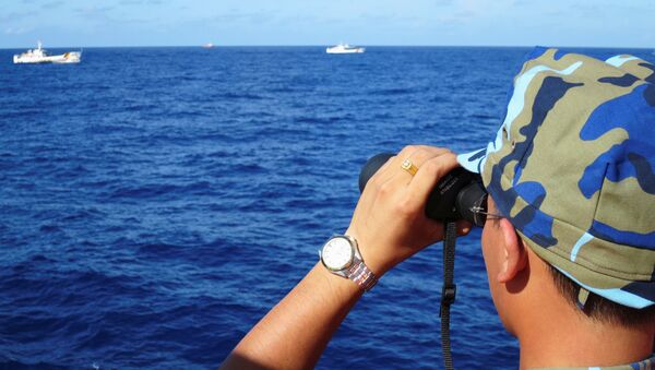 A crewman from the Vietnamese coastguard ship 8003 looks out at sea as Chinese coastguard vessels give chase to Vietnamese ships that came close to the Haiyang Shiyou 981, known in Vietnam as HD-981, oil rig in the South China Sea, July 15, 2014. - Sputnik International