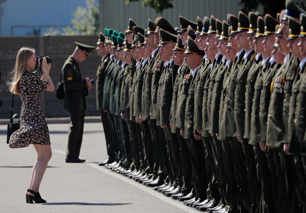 A woman takes photos of graduates as they stand in line while receiving diplomas at the Military Academy of Belarus, amid the coronavirus disease (COVID-19) outbreak in Minsk, Belarus June 27, 2020 - Sputnik International
