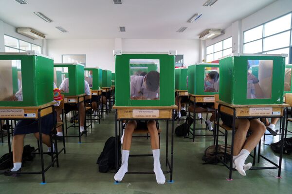 Students of Sam Khok school wearing face masks and face shields are seen inside old ballot boxes repurposed into partitions as they attend a class after the Thai government eased isolation measures and introduced social distancing to prevent the spread of the coronavirus disease (COVID-19), as schools nationwide reopen, at Pathum Thani province, Thailand, July 1, 2020 - Sputnik International