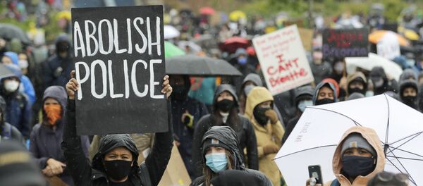 A protester holds a sign that reads Abolish Police during a Silent March against racial inequality and police brutality that was organized by Black Lives Matter Seattle-King County, Friday, June 12, 2020, in Seattle - Sputnik International