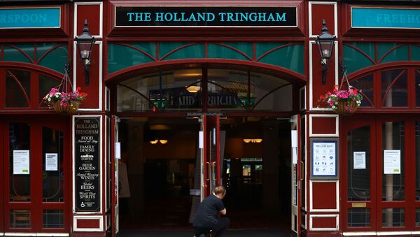 A staff member opens the doors of The Holland Tringham Wetherspoons pub - Sputnik International