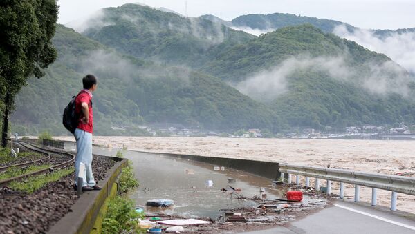 A man looks at the overflowing kuma river caused by heavy rain in Yatsushiro, Kumamoto prefecture on July 4, 2020. - Some 75,000 people were ordered to evacuate in western Japan on July 4 as record heavy rain triggered floods and landslides, local media and officials said. The nation's weather agency issued the highest level of heavy rain warnings to Kumamoto and Kagoshima on Kyushu island. - Sputnik International