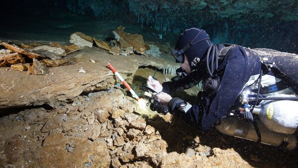 A diver from Centro Investigador del Sistema Acuifero de Q Roo (CINDAQ A.C.) examines an ochre extraction pit in the mine found in a cave that is now underwater in Mexico's Yucatan Peninsula, in this undated picture obtained by Reuters on July 2, 2020. CINDAQ.ORG - Sputnik International
