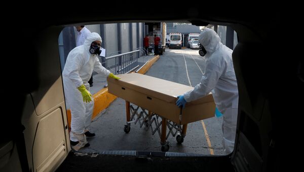 Funeral workers transport the body of a person who died of the coronavirus disease (COVID-19) inside a cardboard coffin, after collecting it from a hospital in Mexico City, Mexico June 5, 2020.  - Sputnik International