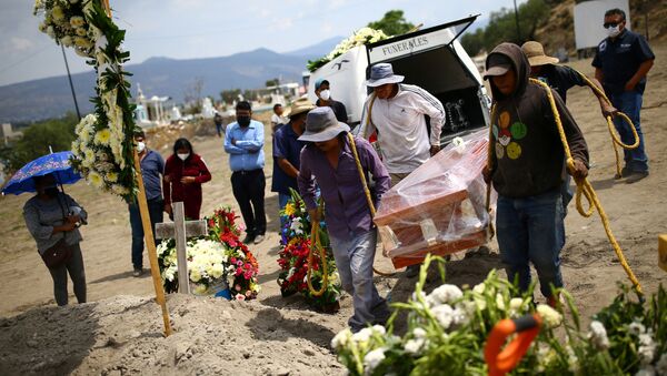 Cemetery workers carry the coffin containing the body of Juana, 50, who died of the coronavirus disease (COVID-19) next to a grave at the Xico cemetery on the outskirts of Mexico City, Mexico, June 10, 2020.  - Sputnik International