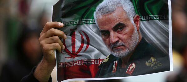 An Iranian holds a picture of late General Qassem Soleimani, head of the elite Quds Force, who was killed in an air strike at Baghdad airport, as people gather to mourn him in Tehran, Iran January 4, 2020.  - Sputnik International
