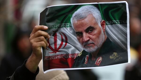 An Iranian holds a picture of late General Qassem Soleimani, head of the elite Quds Force, who was killed in an air strike at Baghdad airport, as people gather to mourn him in Tehran, Iran January 4, 2020.  - Sputnik International