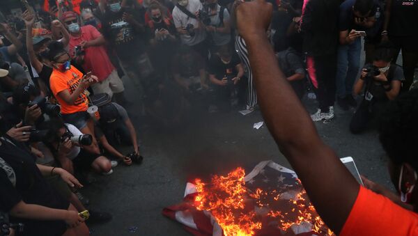 A group of protesters burn American flags and leaflets with the flag, even as other protesters disagreed with the act, during a protest against racial inequality and police violence near Black Lives Matter Plaza, during Fourth of July holiday, in Washington, DC. 4 July 2020. - Sputnik International