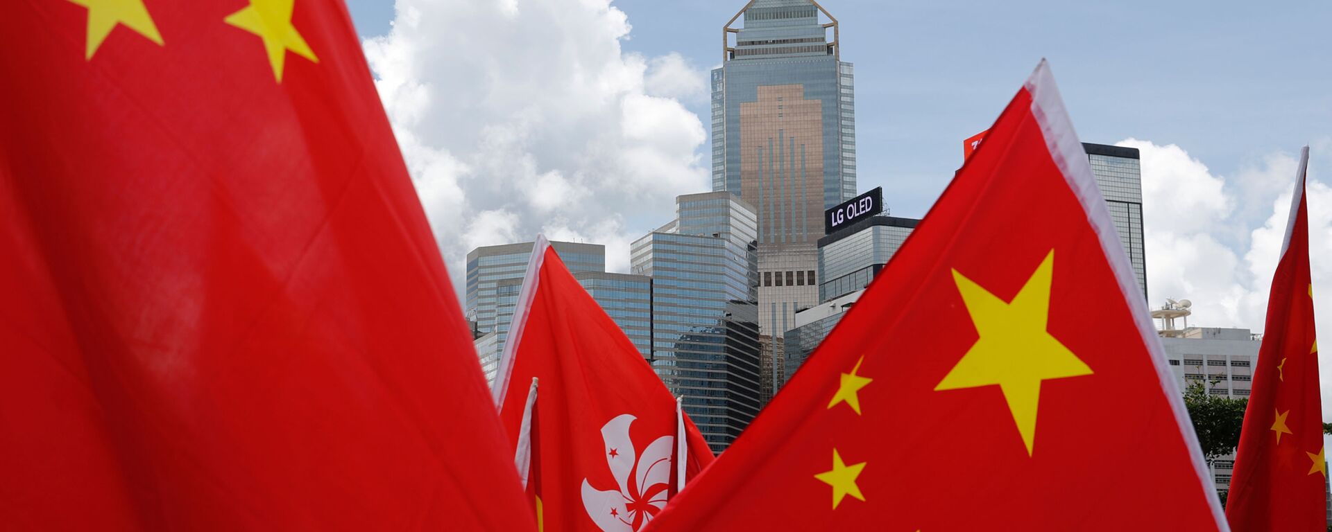 Buildings are seen above Hong Kong and Chinese flags, as pro-China supporters celebration after China's parliament passes national security law for Hong Kong, in Hong Kong, China June 30, 2020. REUTERS/Tyrone Siu - Sputnik International, 1920, 11.03.2021