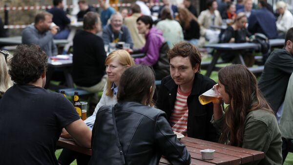 People drinking outside a pub in London on 4 July 2020 - Sputnik International