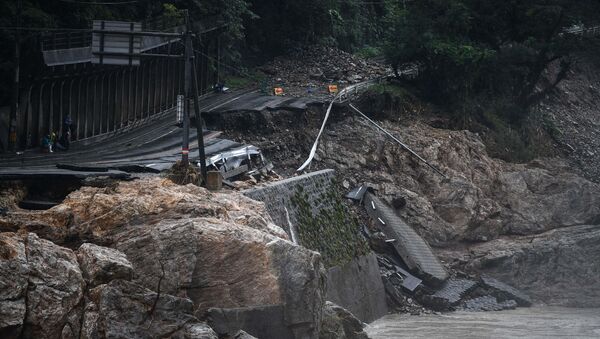 A collapsed road caused by heavy rain is seen in Kuma, Kumamoto prefecture on July 7, 2020. - Emergency services in western Japan were racing against time to rescue people stranded by devastating floods and landslides, with at least 50 feared dead and more torrential rain forecast. - Sputnik International