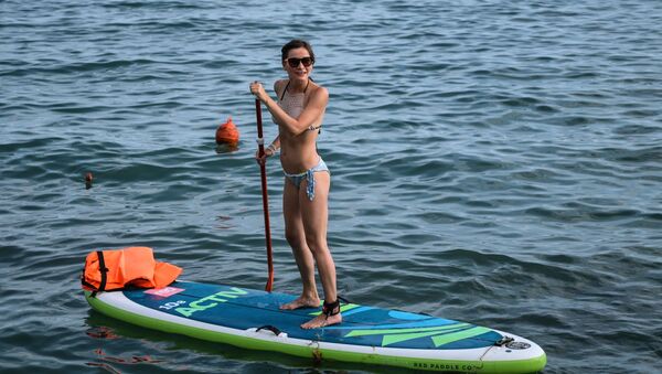 A girl enjoys standup paddleboarding in Sochi - Sputnik International