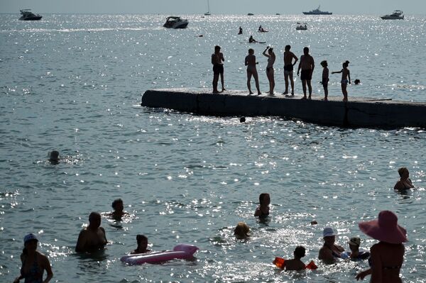 People enjoy a warm summer day on a beach, in the Black Sea resort of Sochi, Russia. - Sputnik International