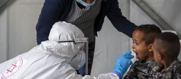 A child is tested by a healthcare worker for the coronavirus at testing center for migrants in Tel Aviv, Israel, Monday, July 6, 2020. - Sputnik International