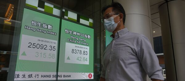 A man wearing a face mask walks past a bank electronic board showing the Hong Kong share index at Hong Kong Stock Exchange Tuesday, June 9, 2020. A man wearing a face mask walks past a bank electronic board showing the Hong Kong share index at Hong Kong Stock Exchange Tuesday, June 9, 2020. - Sputnik International
