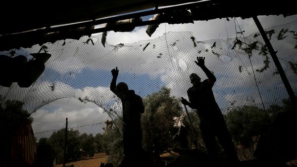 Palestinians fix a damaged fence at the site of an Israeli airstrike in Gaza City July 6, 2020 - Sputnik International