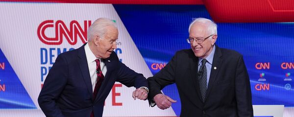 Former Vice President Joe Biden, left, and Sen. Bernie Sanders, I-Vt., right, greet one another before they participate in a Democratic presidential primary debate at CNN Studios in Washington, Sunday, March 15, 2020 - Sputnik International