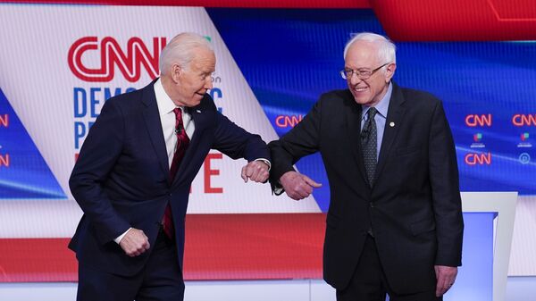 Former Vice President Joe Biden, left, and Sen. Bernie Sanders, I-Vt., right, greet one another before they participate in a Democratic presidential primary debate at CNN Studios in Washington, Sunday, March 15, 2020 - Sputnik International