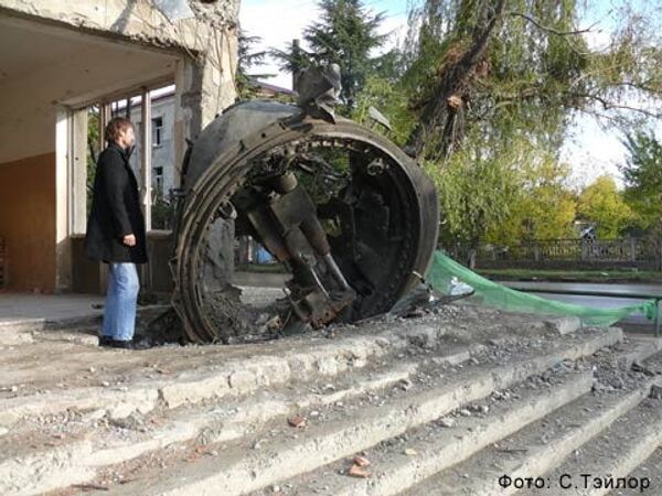 RIA Novosti Correspondent David Burghardt in front of Georgian tank gun buried in foundation of building - Sputnik International